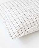 Cushion cover with pom poms in Charcoal grid